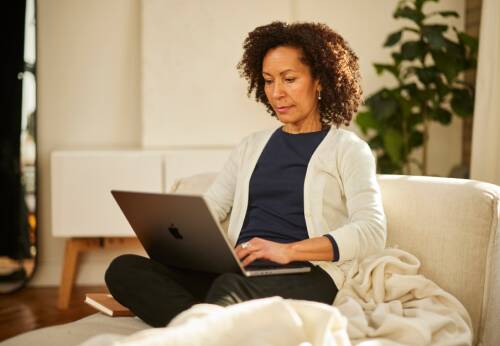 Woman sitting on couch with laptop