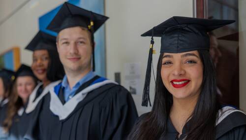 Two graduates standing together smiling